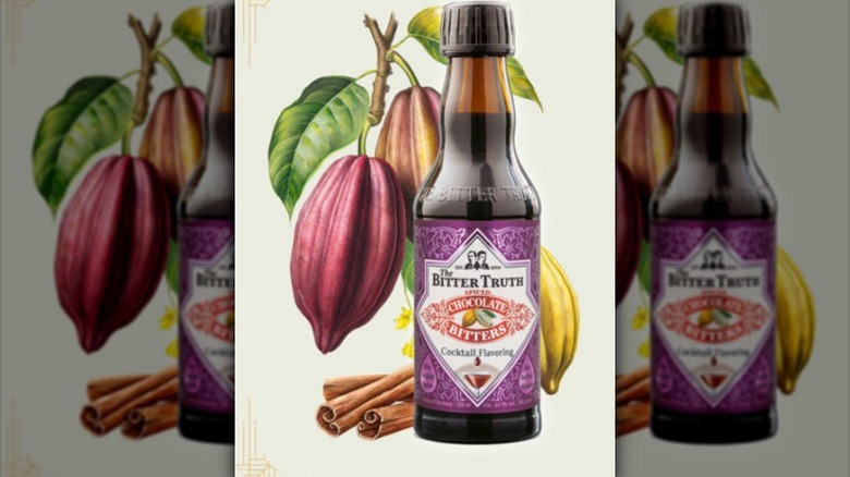 A bottle of chocolate bitters in front of a painting of a cacao plant