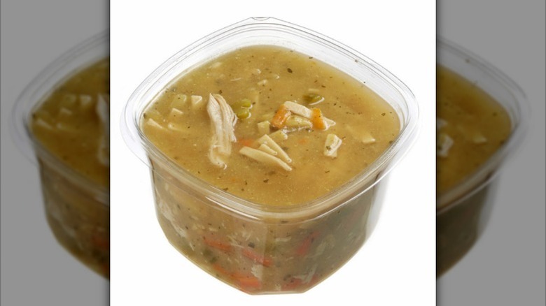 A container of Costco rotisserie chicken noodle soup against a white background