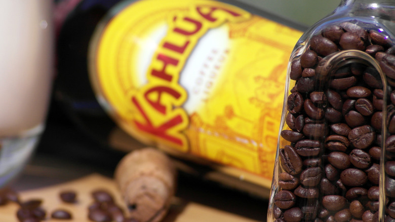 A Kahlúa bottle on its side, next to jar of coffee beans