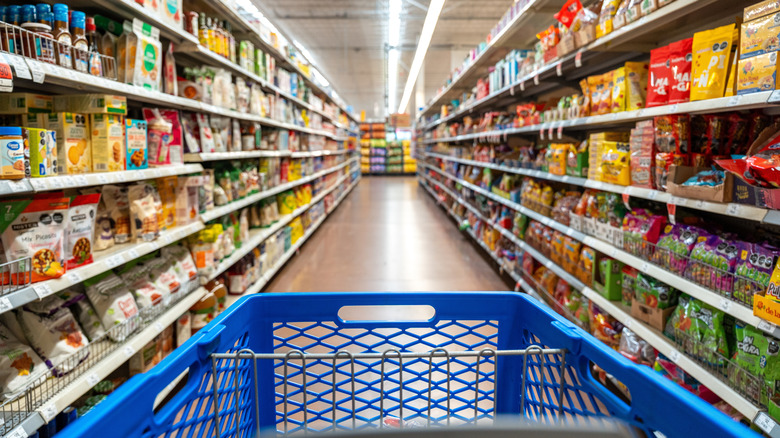 A Walmart shopping cart in a Walmart aisle