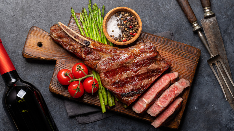 A medium-rare, grilled Tomahawk beef steak with asparagus.