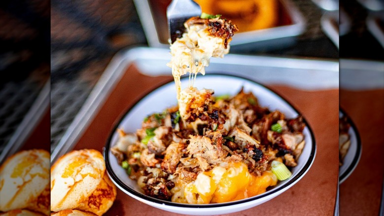 A fork scooping a bite of Jim 'N Nick's loaded mac and cheese