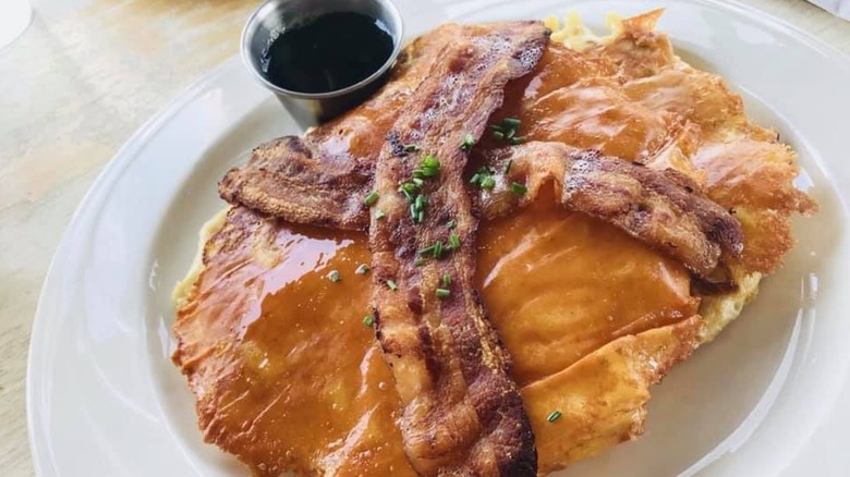 A plate of Morning Glass Coffee's mac and cheese pancakes topped with bacon