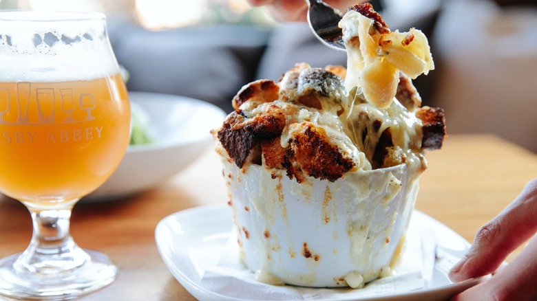 A fork scooping a bite from a bowl of Armsby Abbey mac and cheese