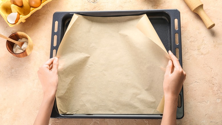 laying parchment paper in baking pan