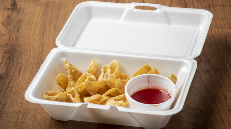 Crab rangoon and sauce in white take out container