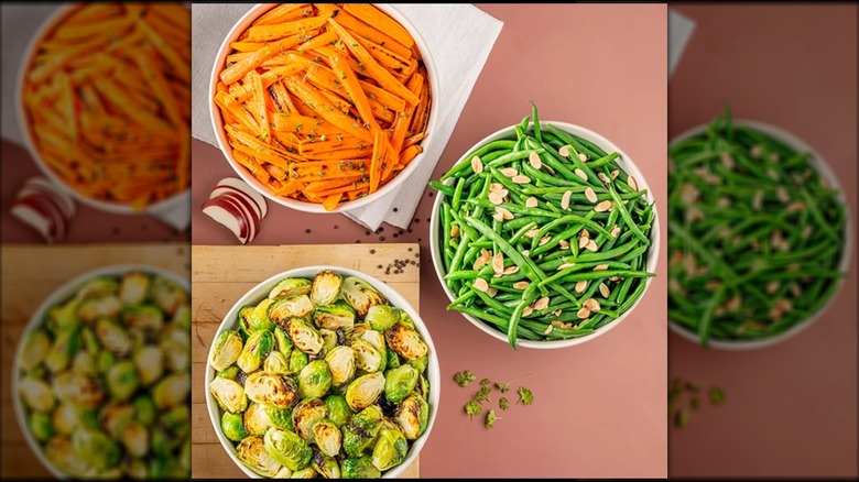 Costco's serving bowls on a table, one with Brussels sprouts, one with carrots, and one with green beans.