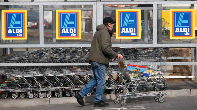 Customer pushing cart with items outside of an Aldi store