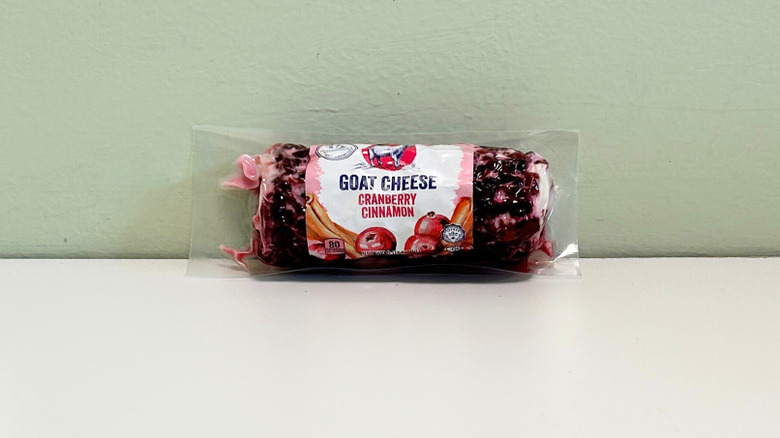 A log of Emporium Selection cranberry cinnamon goat cheese against a green and white background