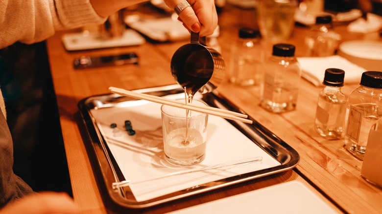 Melted wax being poured into a glass during candle making