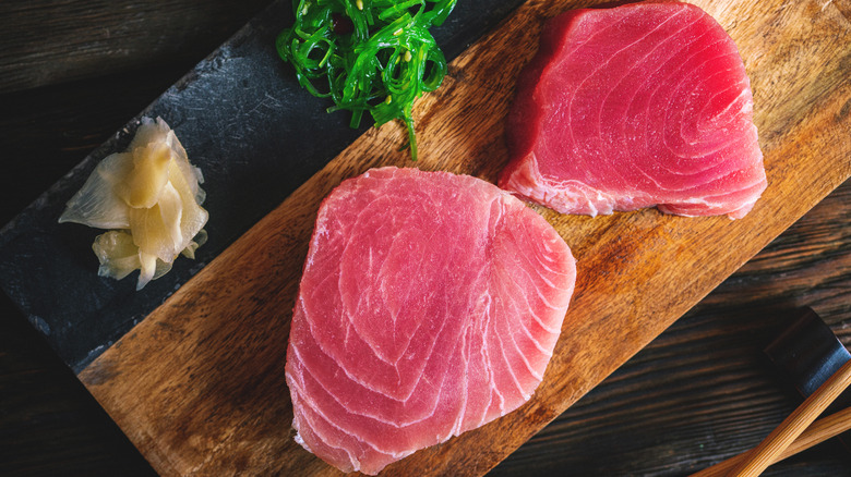 raw tuna steaks on a cutting board