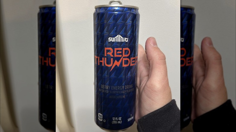 Person holding up can of Red Thunder energy drink