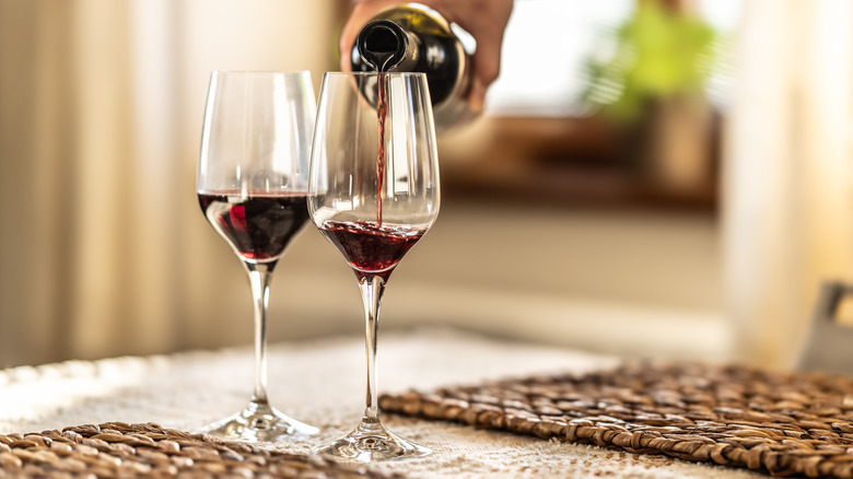 Person pouring red wine