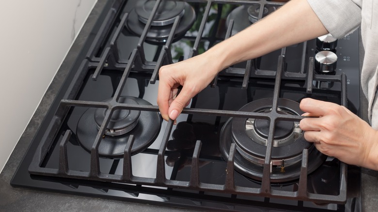 Person placing grates on stove