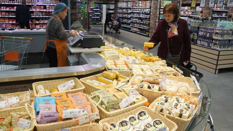 person shopping at store cheese counter