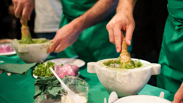 People making traditional pesto