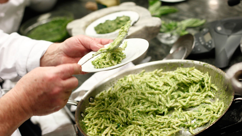 Chef serving pesto pasta