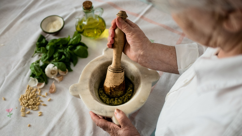 person making traditional pesto