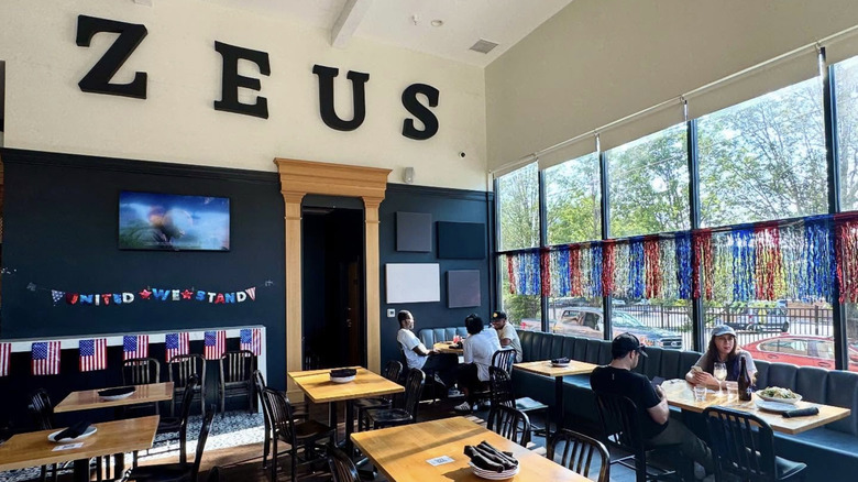 Zeus Brewing Co. interior with customers seated at tables.