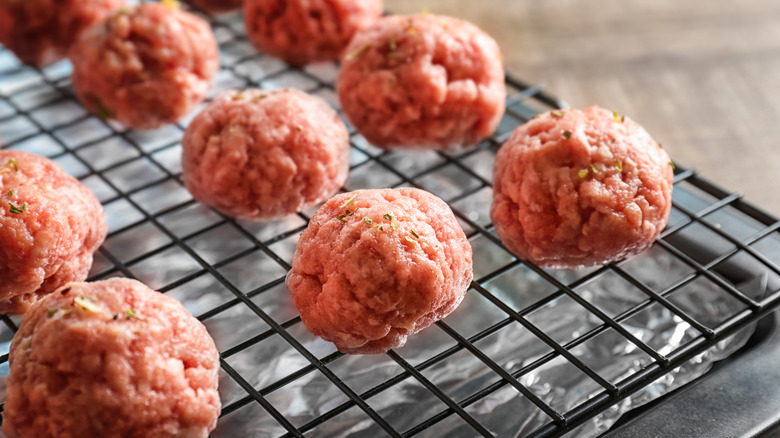 Raw meatballs on baking rack