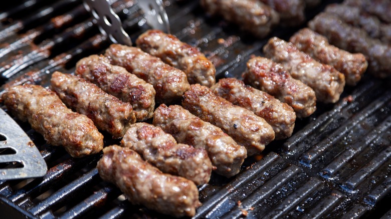 Ćevapi lined up on grill