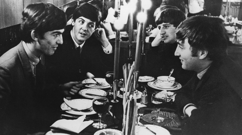 Photo of the Beatles seated at a restaurant table