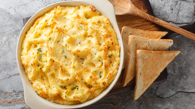 Mashed potatoes with cheddar and parmesan cheese, cream, butter and herbs in a baking dish