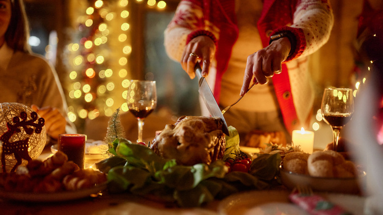 Person slicing turkey at festive holiday table