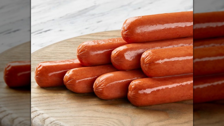 Eight Kirkland Beef Hot Dogs on a cutting board