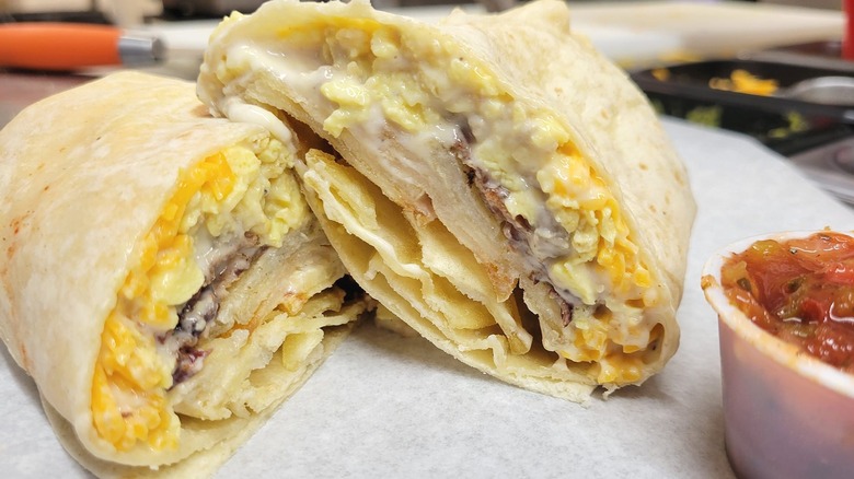 Breakfast burrito cut in half with salsa