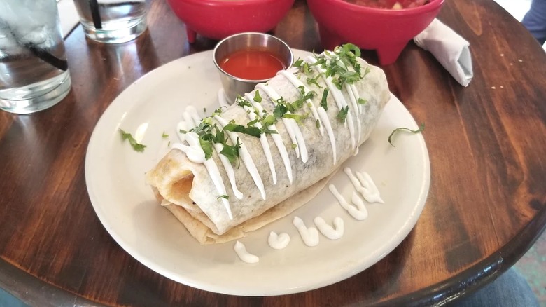 Large breakfast burrito dressed with sour cream & cilantro