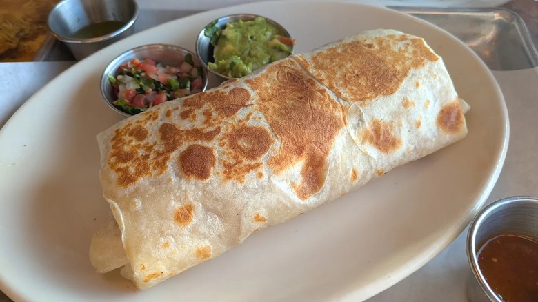 Large breakfast burrito on white plate