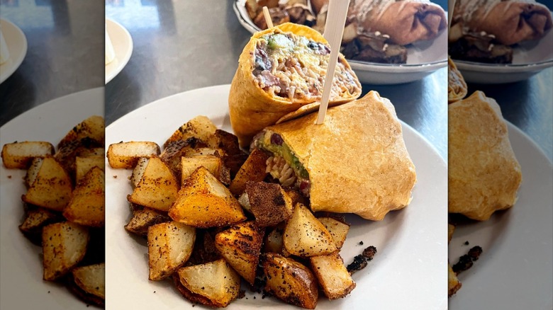 Breakfast burrito cut in half with home fries
