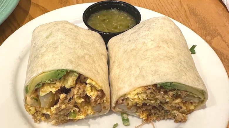 Breakfast burrito cut in half on white plate