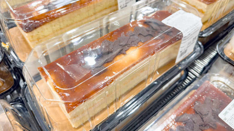 A shelf full of Costco Caramel Tres Leche Bar Cakes in plastic containers