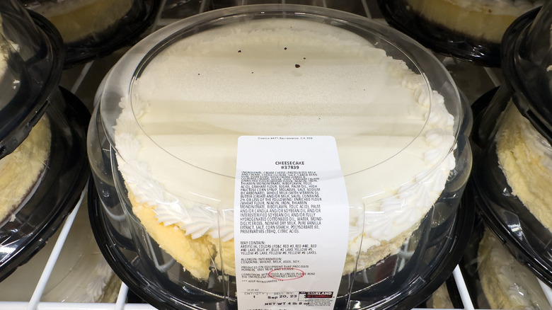 A Costco cheesecake on a wire shelf in a plastic container