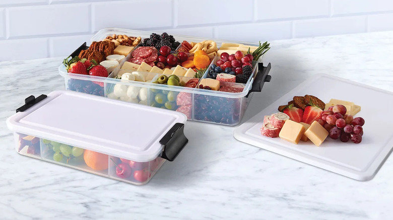 set of two food storage boxes with cutting board lids, filled with array of snack foods