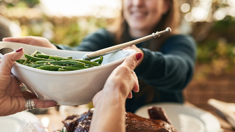 Passing a bowl of green beans at Thanksgiving