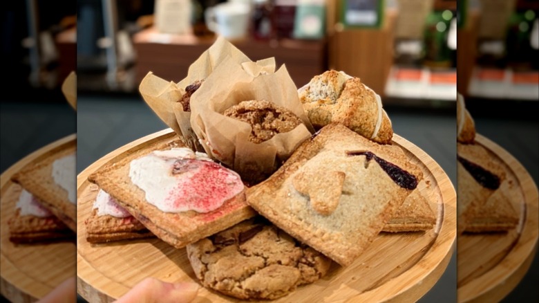 Muffins, cookies, and pastries on wooden circular platter