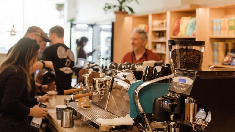 Coffee counter with baristas pouring coffee for customers
