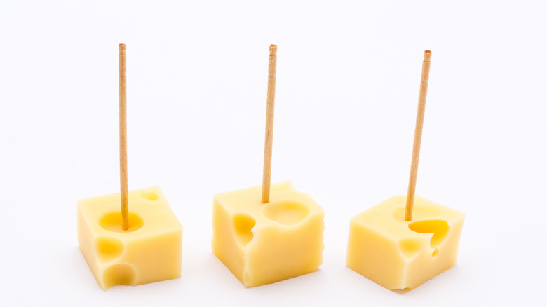 Three pieces of Swiss cheese on toothpicks