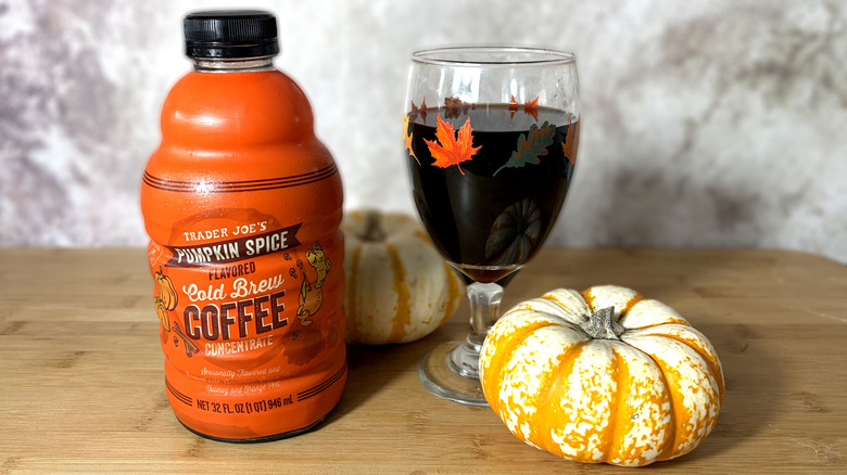 Jug and glass of cold brew coffee with pumpkin decorations