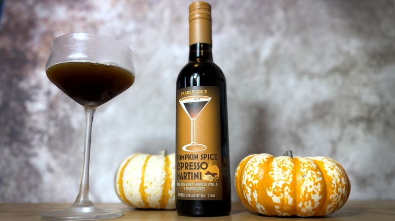 Bottle and glass of espresso martini with pumpkin decorations