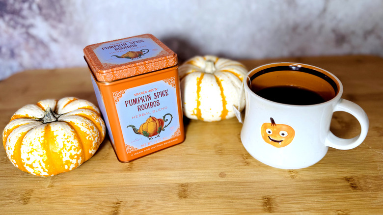 Tin and mug of rooibos tea with pumpkin decorations