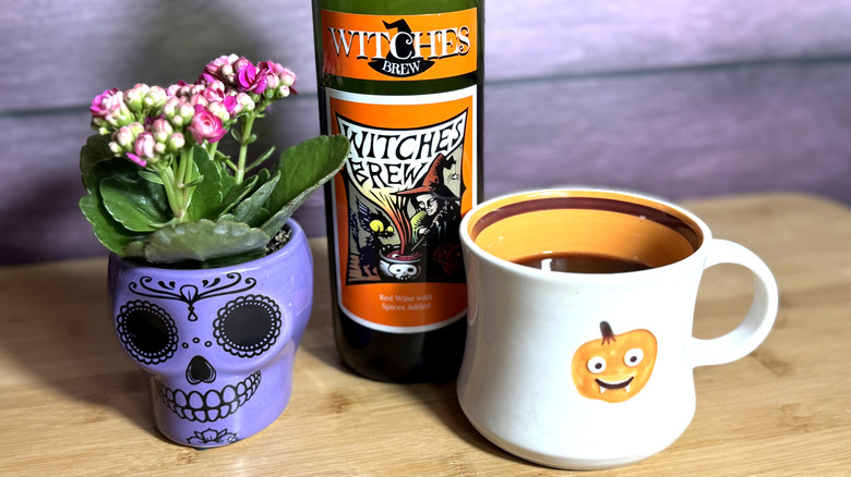 Bottle and mug of mulled wine with skull decoration