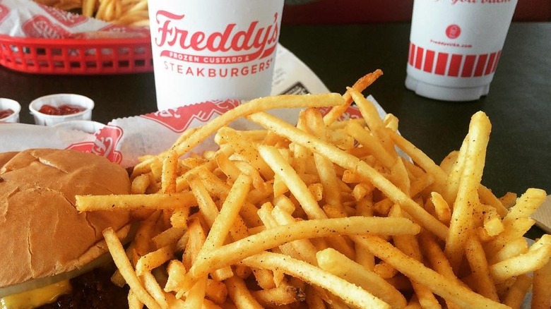 Fries alongside burger and soda