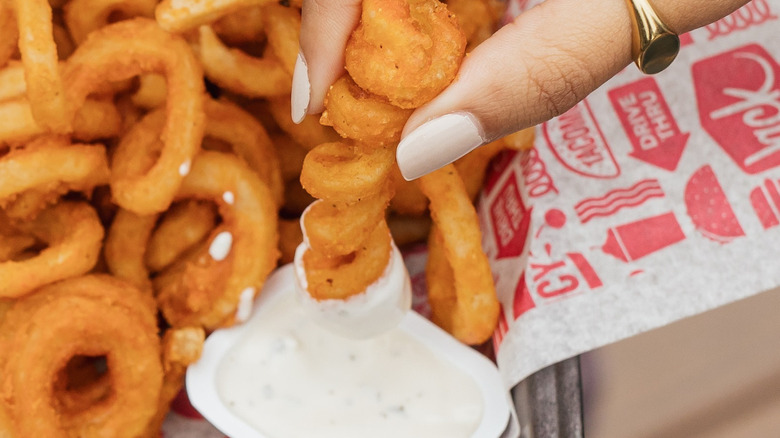 Fingers dipping fry into sauce