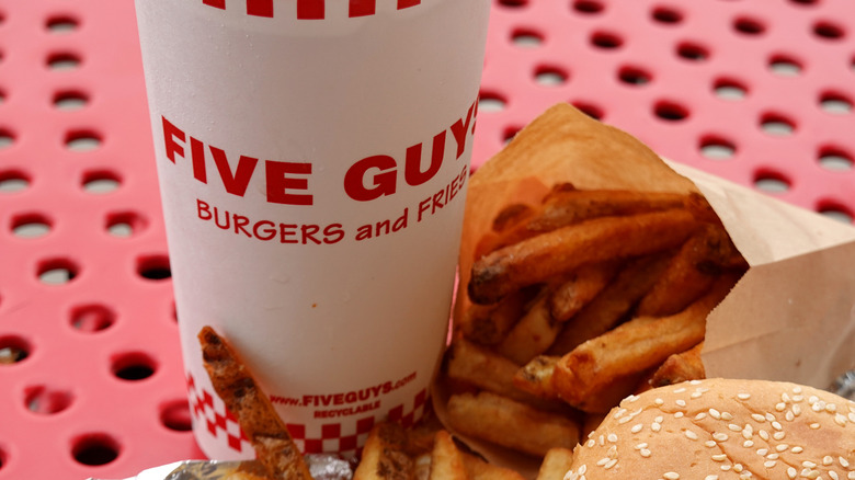 Close up of a Five Guys drink, fries, and a burger bun