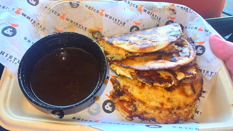A tray of three Crab Smash Tacos with side of dipping sauce