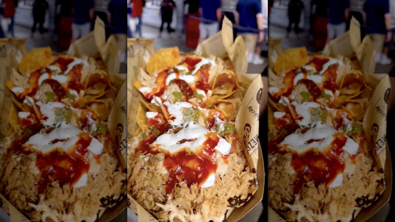 A tray of nachos topped with meat and sauces